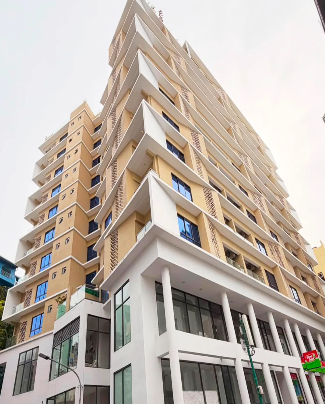 Photograph of LuxaOne, a 9-storey residential building in Malé with angled sand-coloured balcony fins.