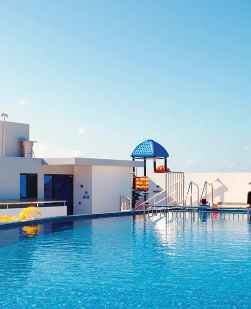 A finished swimming pool with a slide and pool deck.